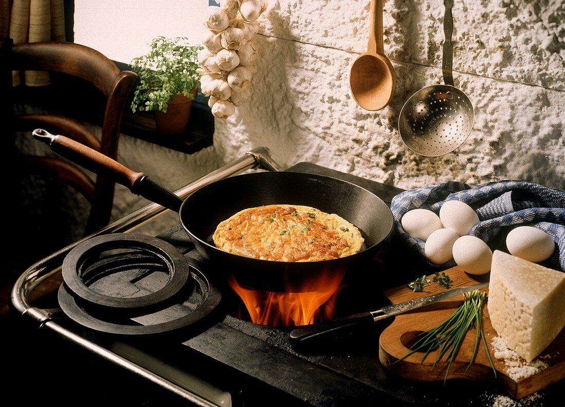 Omelett in Pfanne über Feuer eines antiken Ofens