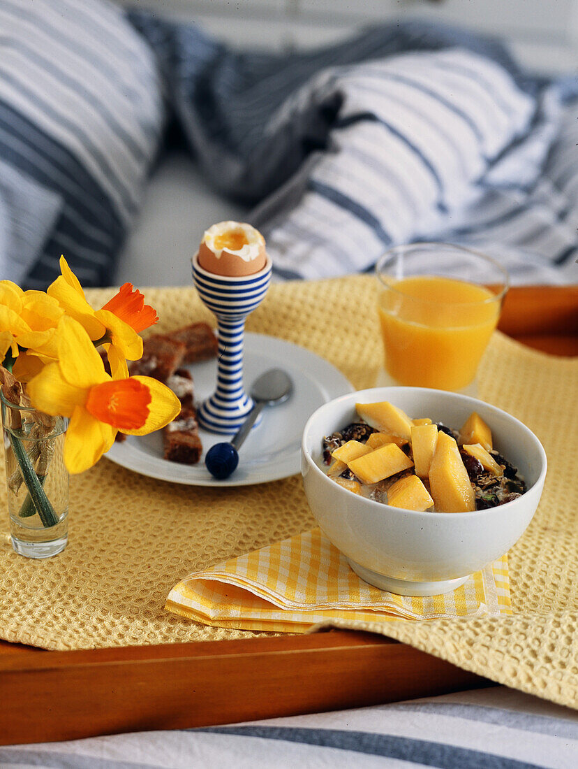 Breakfast tray with muesli, boiled egg and orange juice