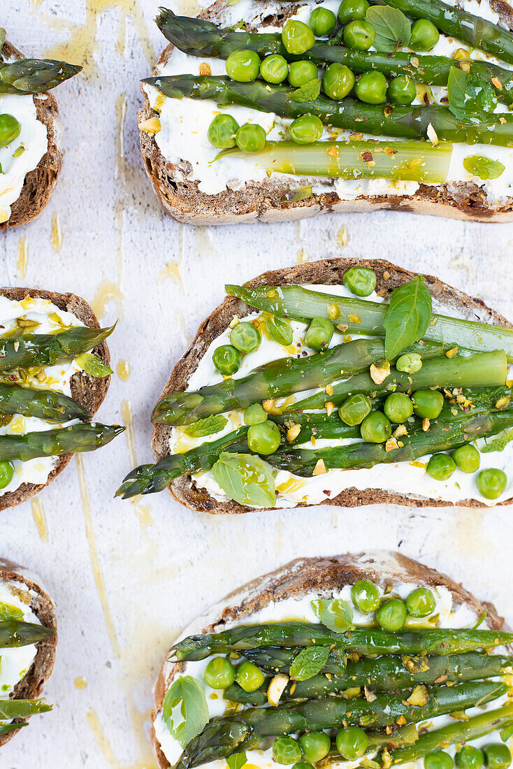 Brotscheiben mit Ziegenkäse, grünen Erbsen und Spargel