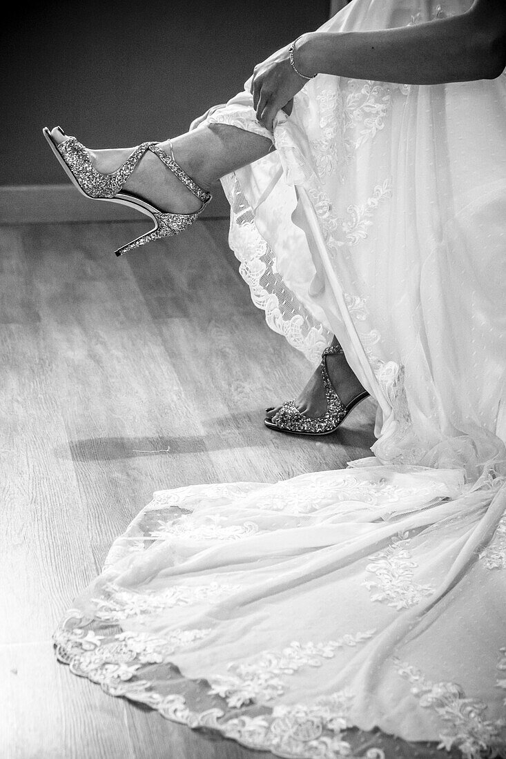Die Braut beim Anziehen ihrer Schuhe, Hochzeitstag