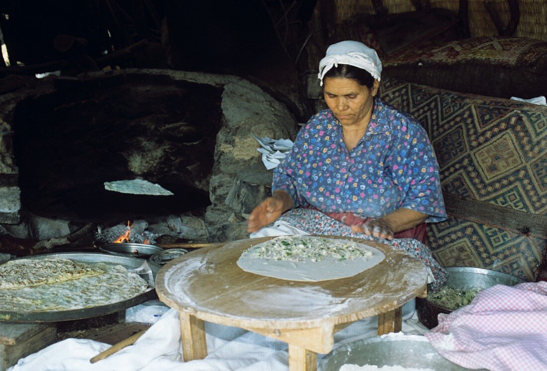 Türkische Frau bei Herstellung von Fladenbroten