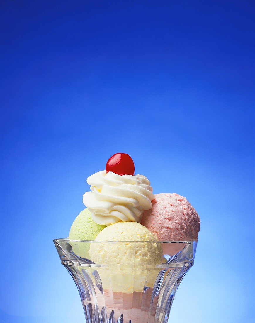 Mixed ice cream sundae with cream and cherry on top