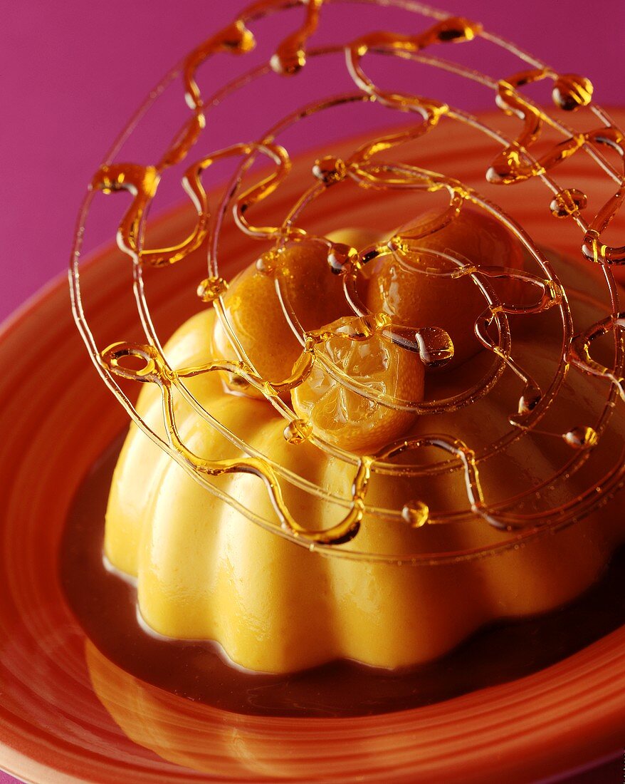 Turned-out crème caramel with caramel spun sugar on plate