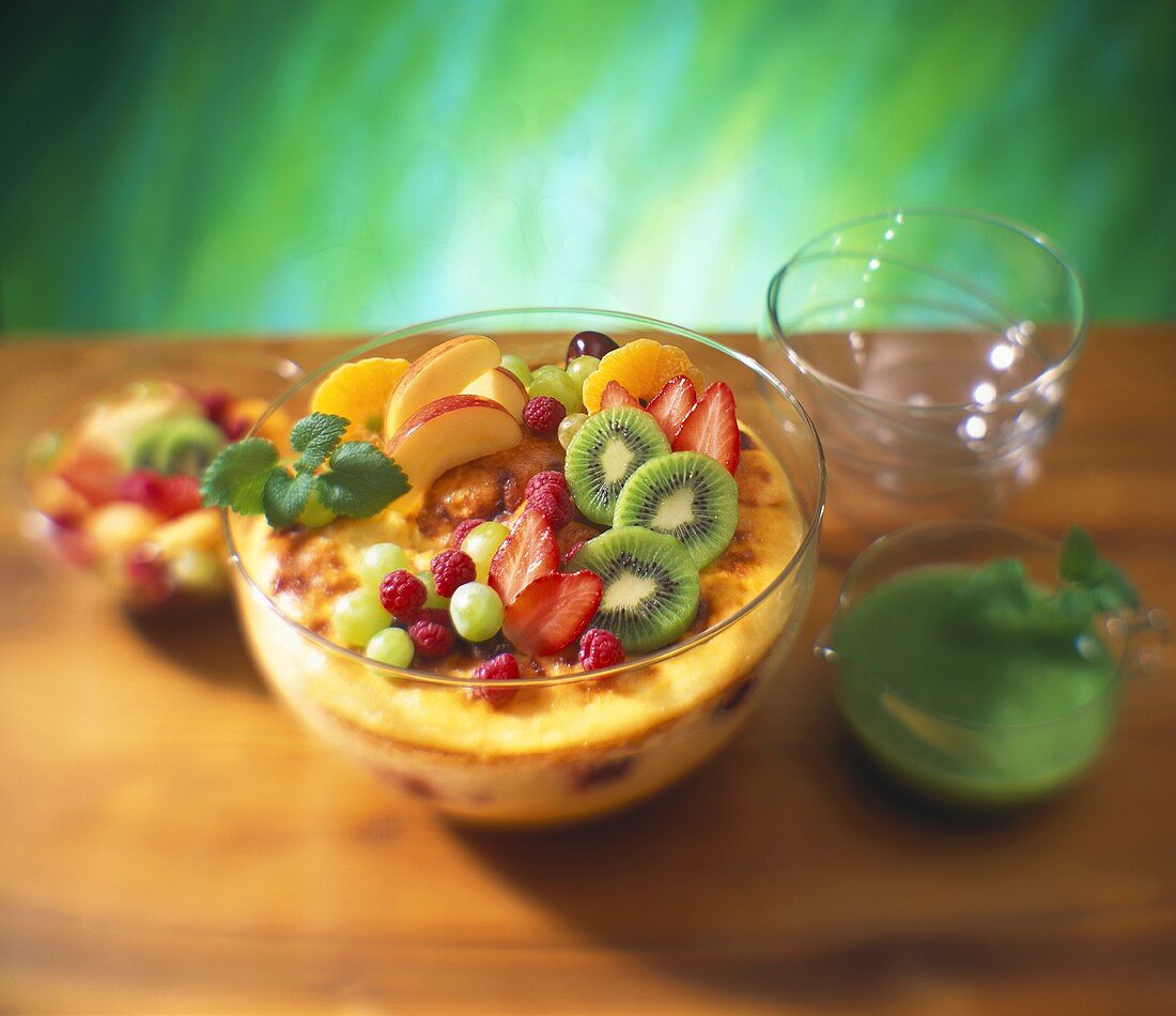 Sweet fruit pudding garnished with fruit in glass bowl