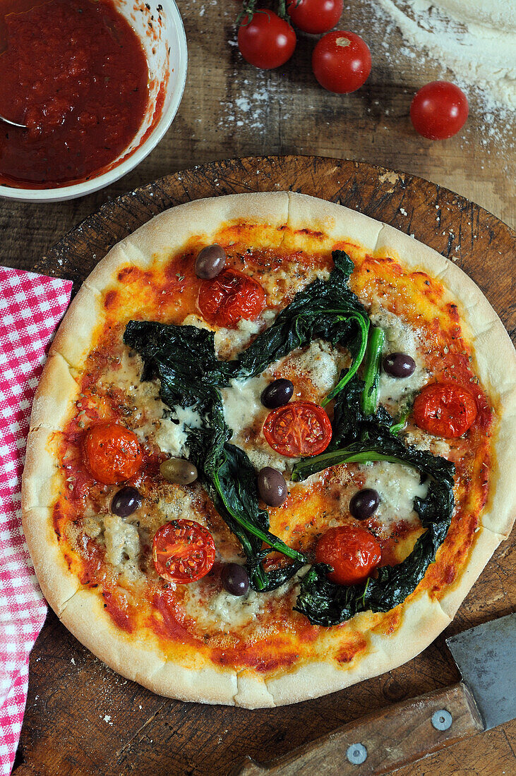 Pizza mit Spinat, Tomaten und Oliven