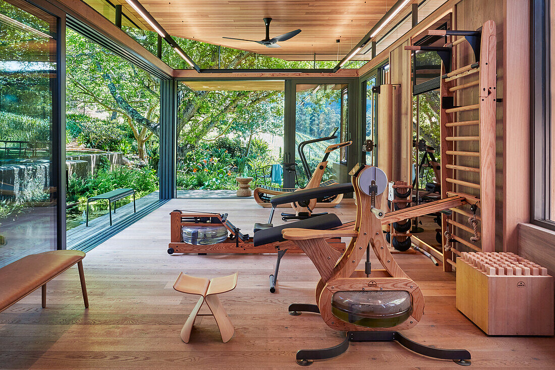 Fitness room with wooden elements and garden view