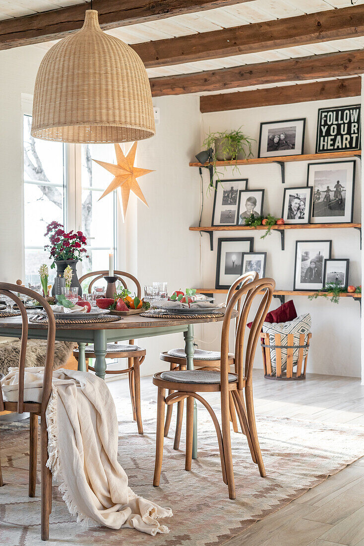 Bright dining area with wooden table, chairs and country-style pendant light