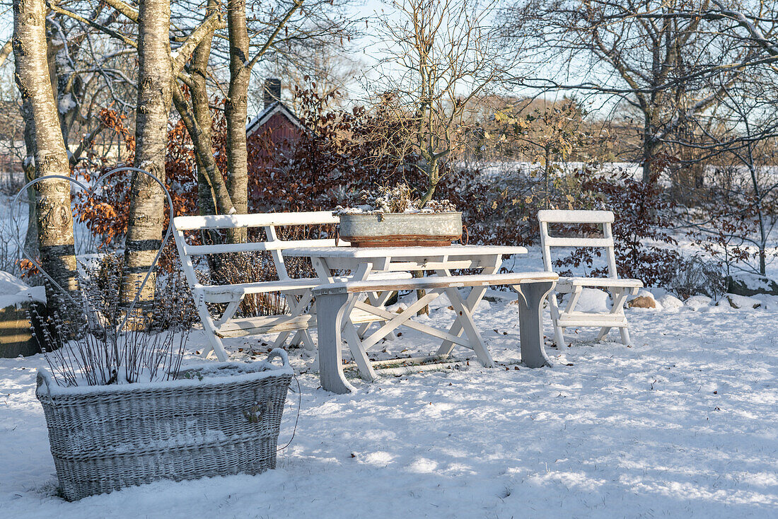 Holzgarnitur mit Bank und Tisch im schneebedeckten Garten