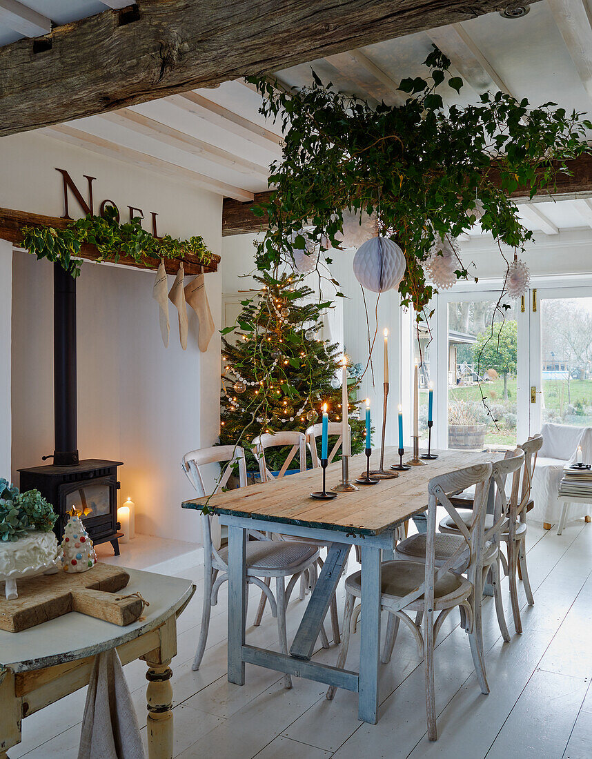 Festively decorated dining area with Christmas tree and tinsel garlands