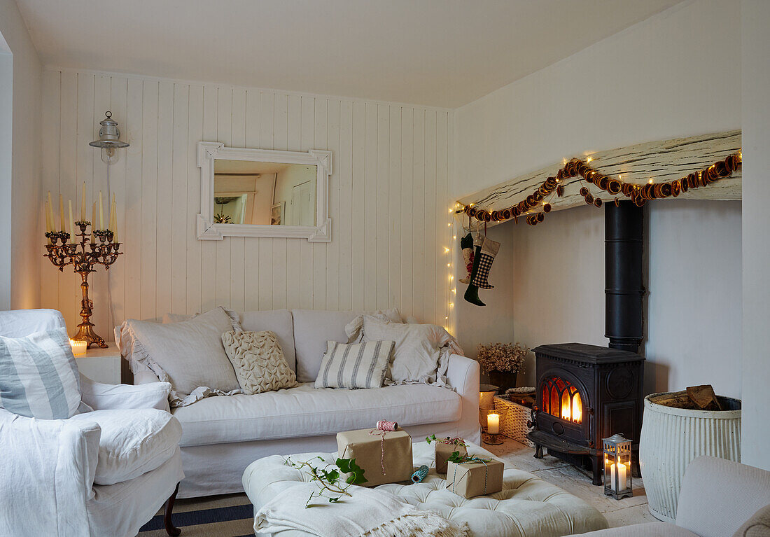 White living room with wood-burning stove, candles and Christmas decorations