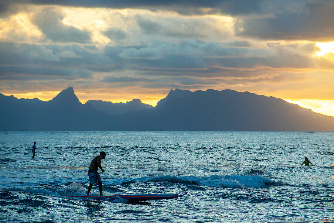 Surfer am Strand mit schwarzem Sand auf Pointe Venus, Tahiti, Französisch-Polynesien, Tahiti Nui, Gesellschaftsinseln, Französisch-Polynesien, Südpazifik.