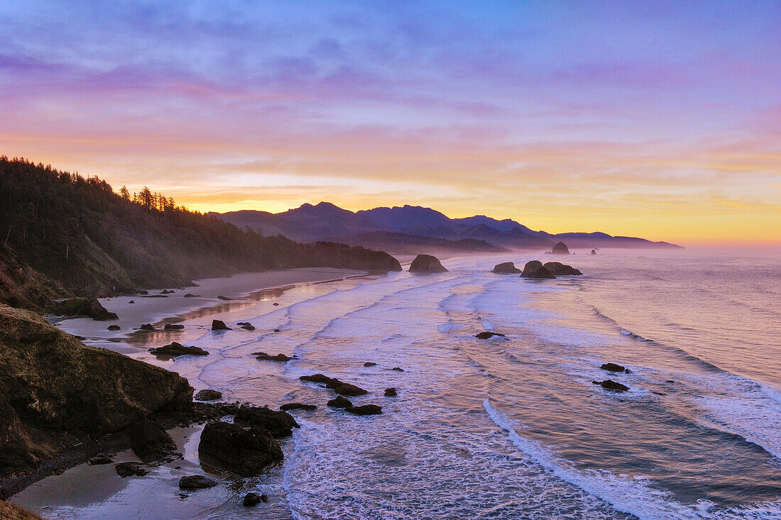 Blick auf Crescent Beach, Cannon Beach, Haystack Rock und die Küste bis Hug Point vom Ecola State Park bei Sonnenaufgang; Oregon.