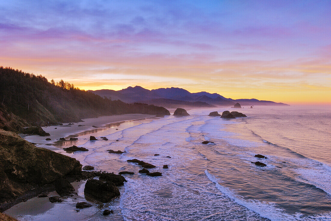 View of Crescent Beach, Cannon Beach, Haystack Rock and coast to Hug Point from Ecola State Park at sunrise; Oregon.