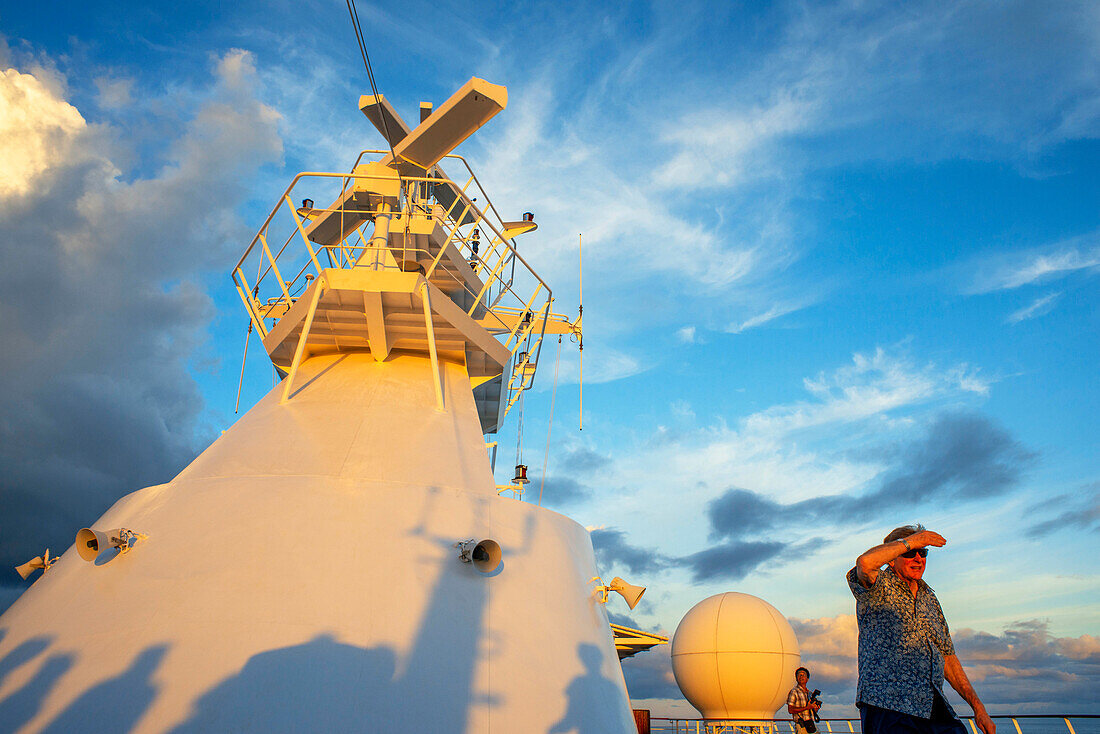 Paul Gauguin Kreuzfahrtschiff, Passagiere entspannen sich auf dem Oberdeck bei Sonnenuntergang. Französisch-Polynesien, Tuamotus-Archipel, Gesellschaftsinseln, Südpazifik.