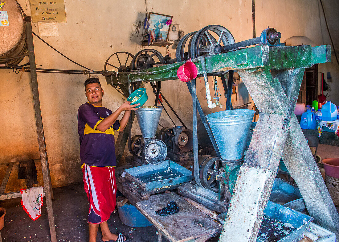 Salvadorianer bei der Arbeit in einer Mais-Tortilla-Teigfabrik in Suchitoto, El Salvador. Mais ist in den mittelamerikanischen Kulturen seit der präkolumbianischen Zeit ein Grundnahrungsmittel.
