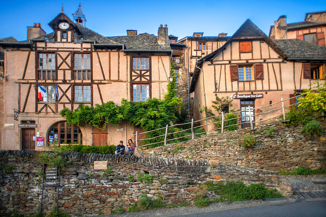 Das kleine mittelalterliche Dorf Conques in Frankreich. Es zeigt dem Besucher seine Abteikirche und die mit Schieferdächern gedeckten Häuser. Durchquerung von engen Gassen und Monolithen für die Gefallenen des Krieges im alten mittelalterlichen Dorf Conques am Ufer des Flusses Dordou