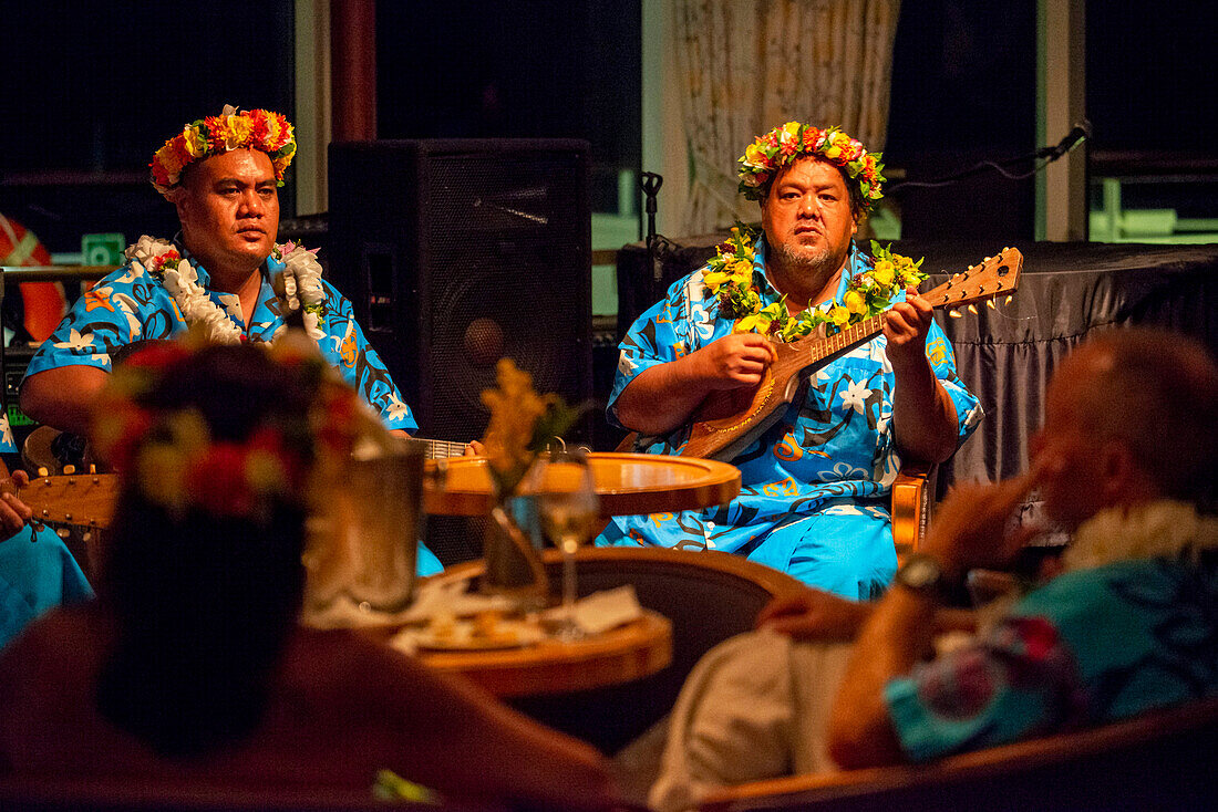 Entertainment group singing in the Paul Gauguin cruise ship. France, French Polynesia, Polynesian, South Pacific.