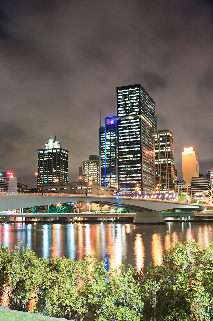 Spiegelung der bunten Lichter der Skyline des Stadtzentrums von Brisbane im Brisbane River bei Nacht, Queensland, Australien. Dieses Foto von Brisbane River und der Spiegelung der Skyline des Stadtzentrums von Brisbane bei Nacht wurde von South Bank aus aufgenommen.