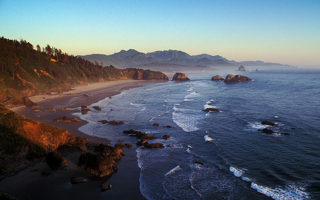 View of Crescent Beach, Cannon Beach, Haystack Rock and coast to Hug Point from Ecola State Park at sunset; Oregon.