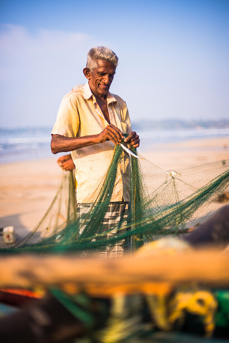 Fischer sortieren ihren Fang am Strand von Weligama, Südküste von Sri Lanka, Asien