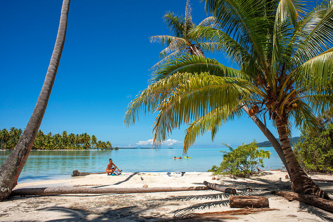 Tropical paradise seascape Taha'a island landscape, French Polynesia. Motu Mahana palm trees at the beach, Taha'a, Society Islands, French Polynesia, South Pacific.