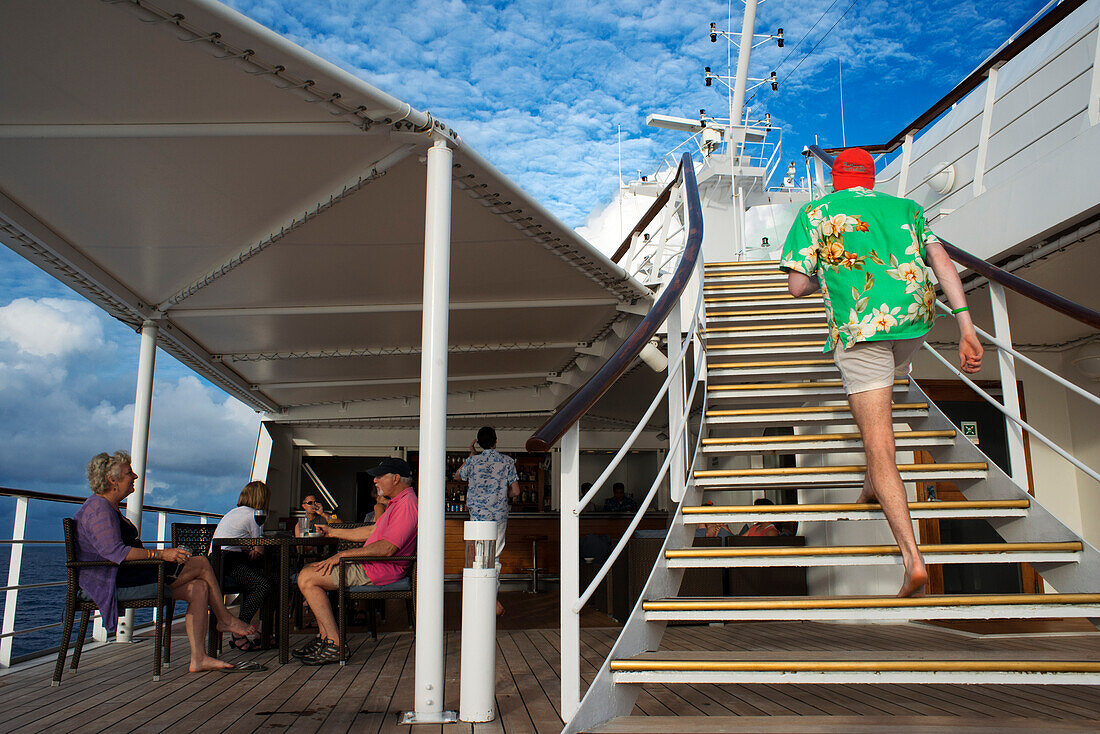 Kreuzfahrtschiff Paul Gauguin, Passagiere entspannen auf dem Oberdeck. Gesellschaftsinseln, Französisch-Polynesien, Südpazifik.