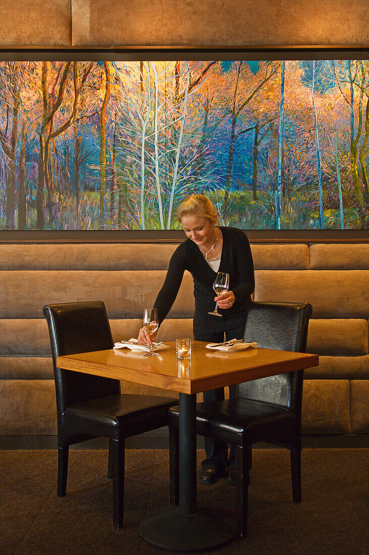 Kellnerin deckt den Tisch im Speisesaal des Celilo Restaurant in Hood River, Oregon.