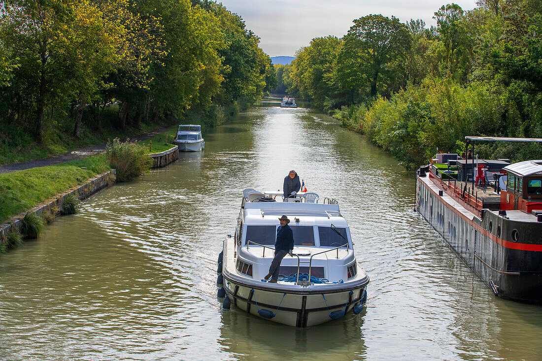 Der Canal du Midi, in der Nähe von Carcassonne, französisches Departement Aude, Region Occitanie, Languedoc-Rousillon Frankreich. Boote, die auf dem von Bäumen gesäumten Kanal vertäut sind. Die Schleuse von Herminis oder Herminis ecluse.
