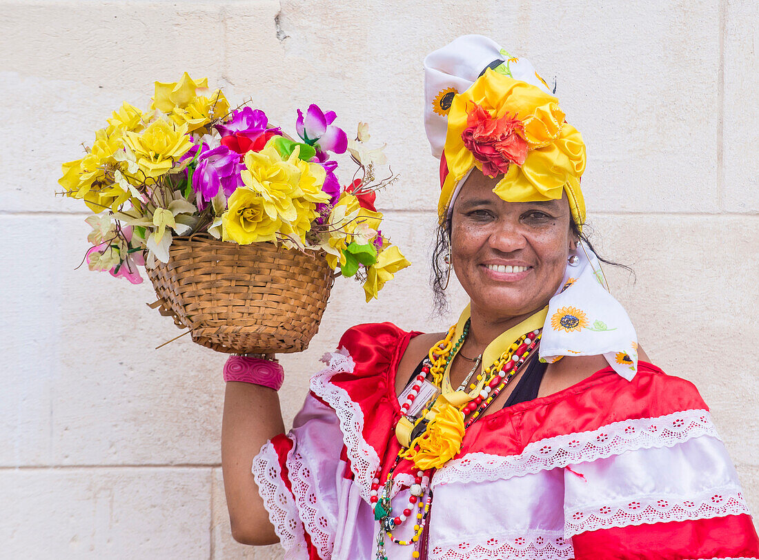 Kubanische Frau mit traditioneller Kleidung in einer Straße in Havanna. Das historische Zentrum von Havanna gehört seit 1982 zum UNESCO-Weltkulturerbe.