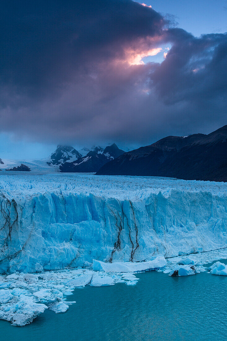 Die zerklüftete Wand des Perito-Moreno-Gletschers und der Lago Argentino im Los-Glaciares-Nationalpark in der Nähe von El Calafate, Argentinien. Ein UNESCO-Weltnaturerbe in der Region Patagonien in Südamerika. Eisberge vom kalbenden Eis des Gletschers schwimmen im See.