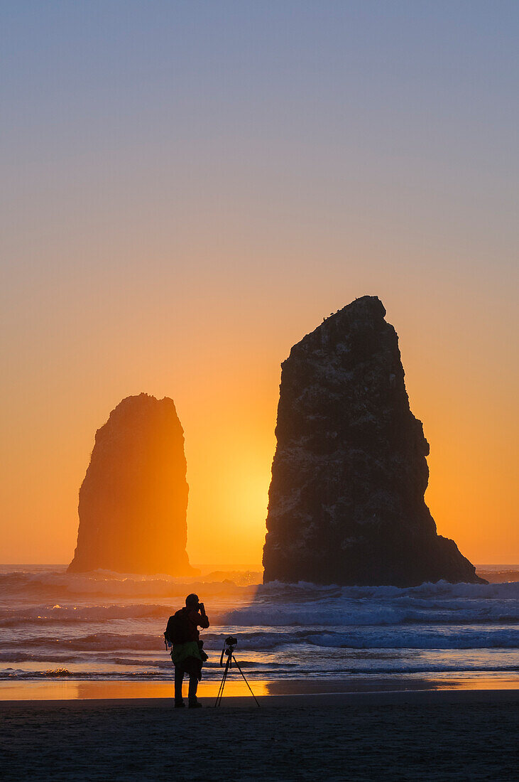 Mann fotografiert die Nadeln am Haystack Rock in Cannon Beach an der Nordküste von Oregon.