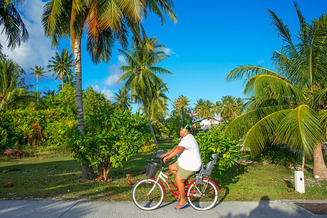 Einheimisches Mädchen mit einem Fahrrad in Fakarava, Tuamotus-Archipel, Französisch-Polynesien, Tuamotu-Inseln, Südpazifik.