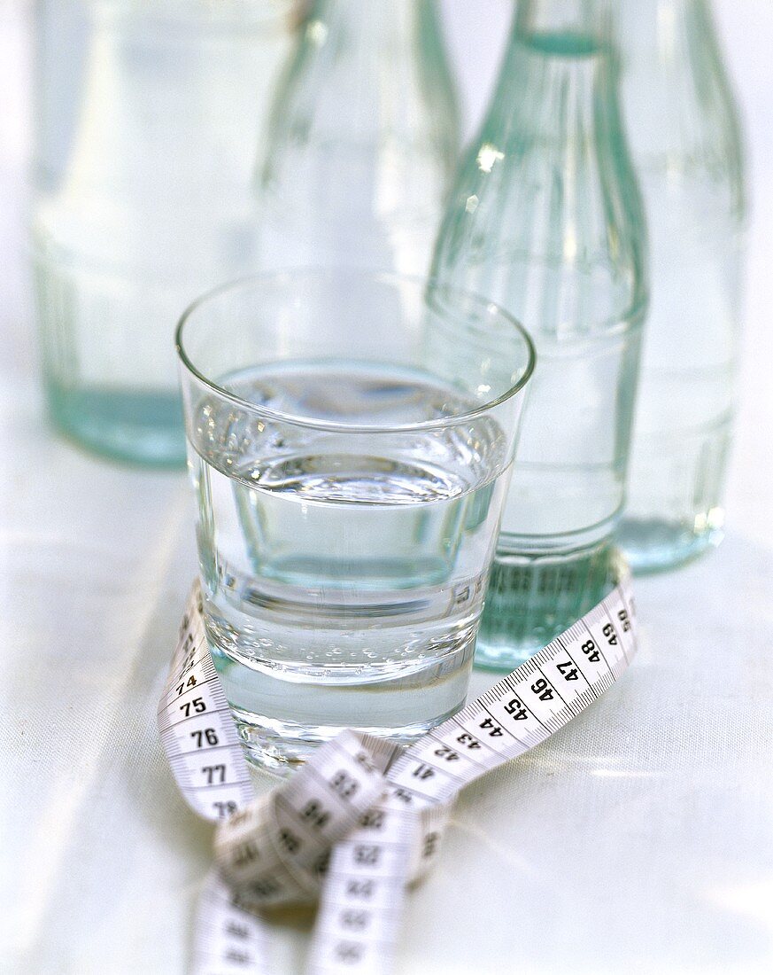 Maßband um Mineralwasserglas & -flaschen gewickelt