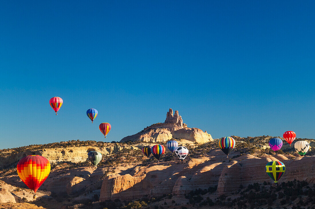 Heißluftballons mit Church Rock im Hintergrund; Red Rock Balloon Rally im Red Rock State Park, Gallup, New Mexico.