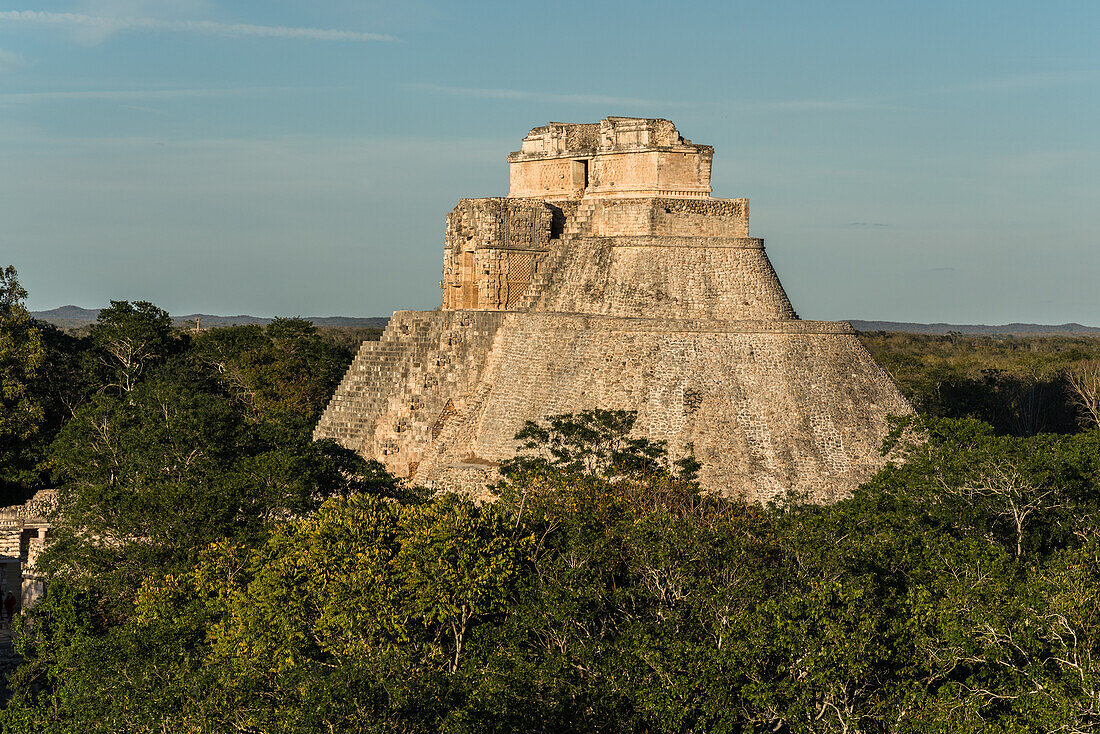 The west facade of the Pyramid of the Magician, also known as the Pyramid of the Dwarf. It is the tallest structure in the pre-Hispanic Mayan ruins of Uxmal, Mexico, rising about 35 meters or 115 feet. The temple at the top of the stairs is built in the Chenes style, while the upper temple is Puuc style.