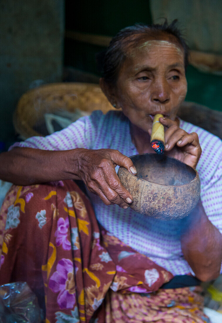 Woman smoking a cheroot cigar in market in Bagan, Myanmar