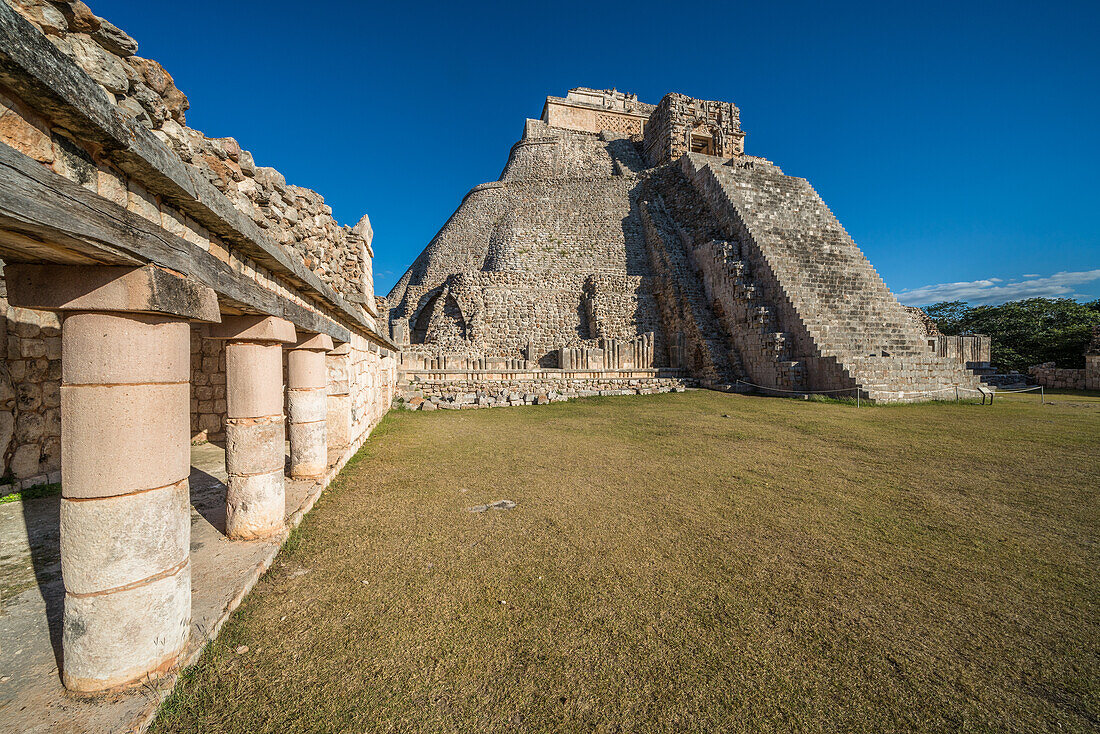 The west facade of the Pyramid of the Magician, also known as the Pyramid of the Dwarf, faces into the Quadrangle of the Birds. It is the tallest structure in the pre-Hispanic Mayan ruins of Uxmal, Mexico, rising about 35 meters or 115 feet. The temple at the top of the stairs is built in the Chenes style, while the upper temple is Puuc style.