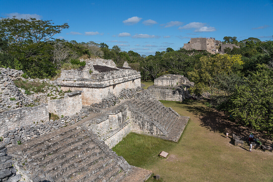Die teilweise restaurierten Ruinen der Zwillingstempel auf der Spitze von Struktur 17 mit der großen Ruine der Akropolis in den Ruinen der prähispanischen Maya-Stadt Ek Balam in Yucatan, Mexiko. Von der Spitze des Ovalpalastes aus gesehen.