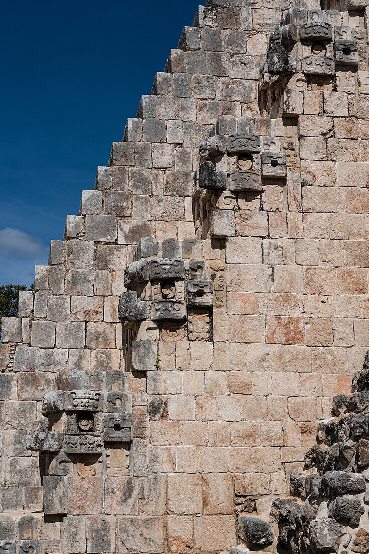A row of Chaac masks line the stairway on the west facade of the Pyramid of the Magician, also known as the Pyramid of the Dwarf in the pre-Hispanic Mayan ruins of Uxmal, Mexico. Chaac is the rain god deity of the Maya.