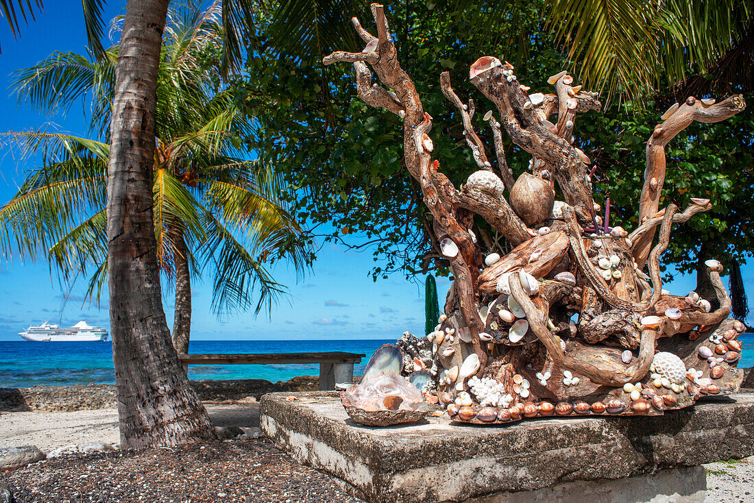 A sculpture with shells on a railing overlooking a tropical lagoon on the island of Fakarava in French Polynesia