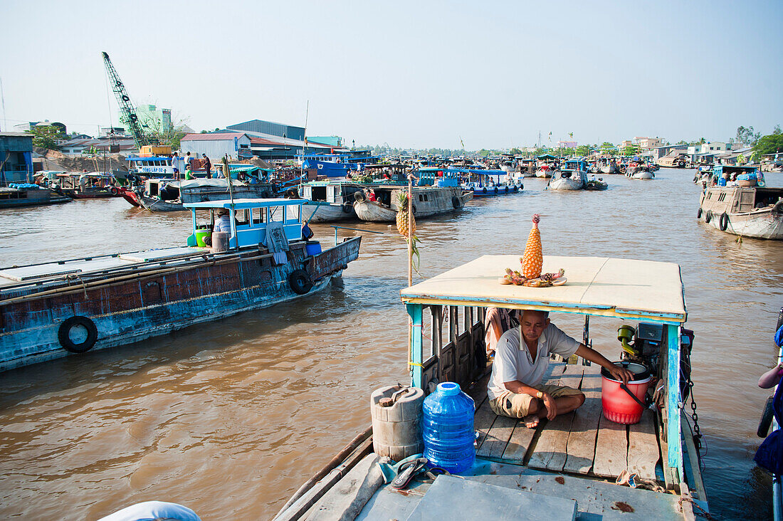 Ananas-Verkaufsboot auf dem schwimmenden Markt von Can Tho, Mekong-Delta, Vietnam. Auf dem schwimmenden Markt von Can Tho herrscht ein reges Treiben. Auf den Booten stapeln sich die Früchte, und die Markthändler verkaufen sowohl untereinander als auch an die vorbeifahrenden Touristen. Es gibt unzählige schwimmende Märkte im Mekong-Delta, aber Can Tho ist einer der größten mit Hunderten von Booten, die sich jeden Morgen aneinander vorbeidrängen, bevor sie sich am nächsten Tag wieder auf den Markt vorbereiten. Jedes Boot hängt ein Exemplar seiner Waren auf, damit die Passanten wissen, was es zu 