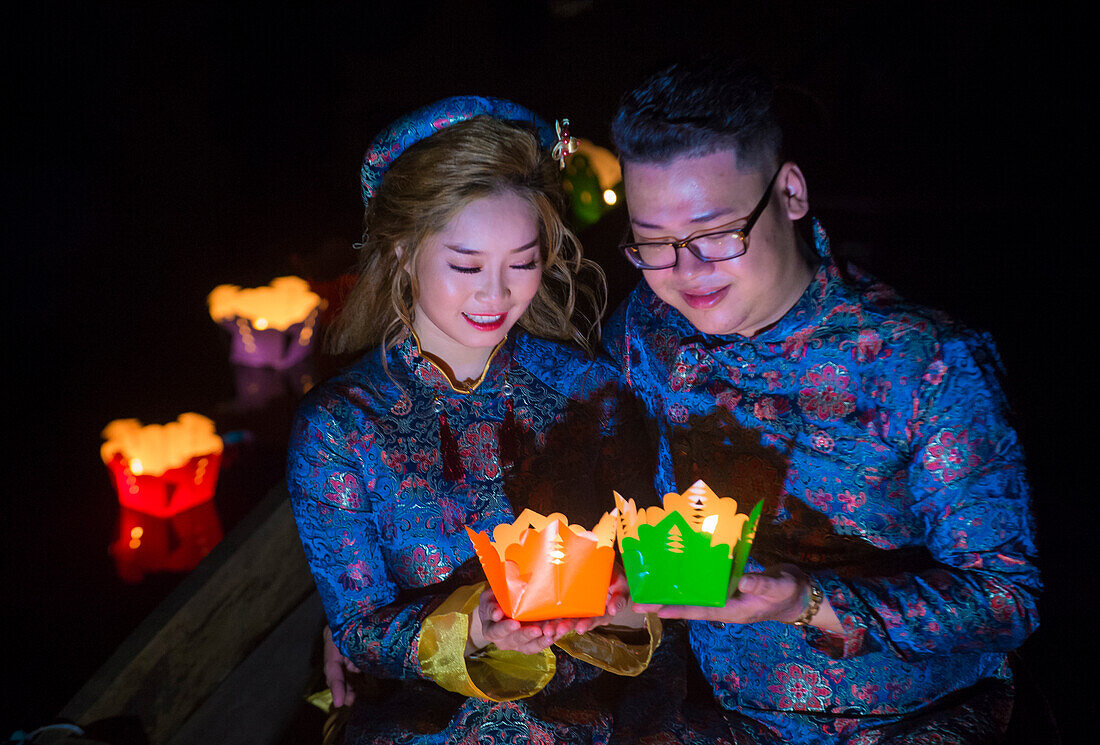 Vietnamese couple holding lanterns before droping them into the river in Hoi An ,Vietnam during the Hoi An Full Moon Lantern Festival