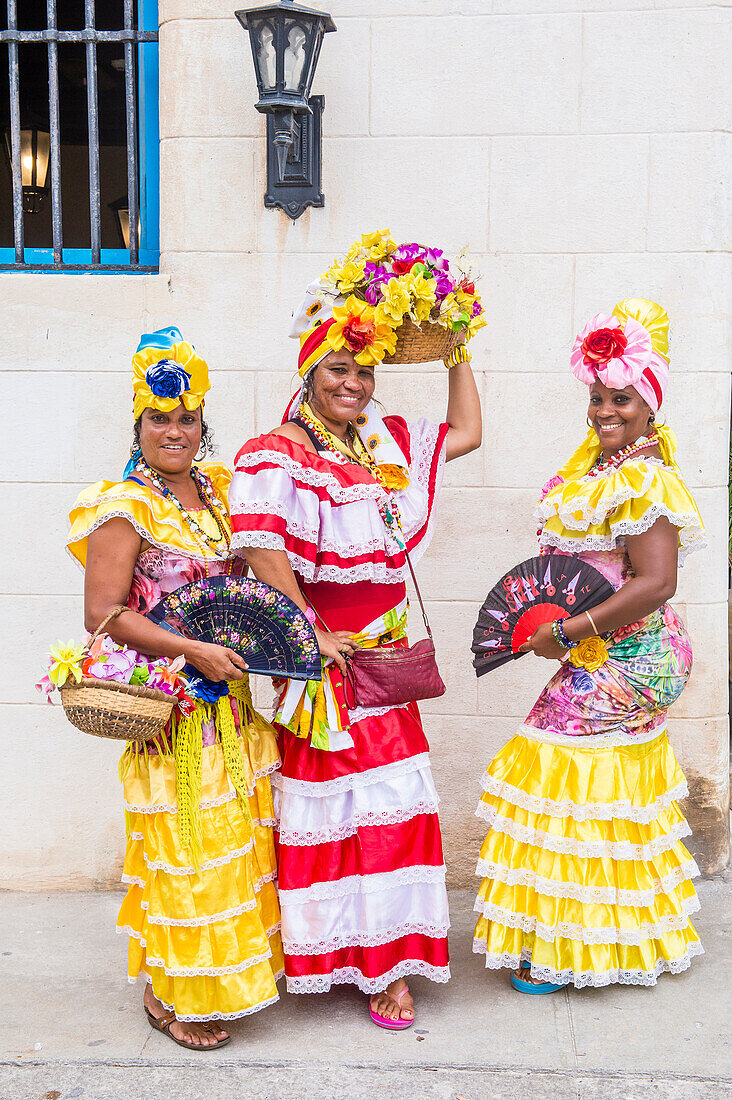 Kubanische Frauen in traditioneller Kleidung in einer Straße der Altstadt von Havanna. Das historische Zentrum von Havanna gehört seit 1982 zum UNESCO-Weltkulturerbe.