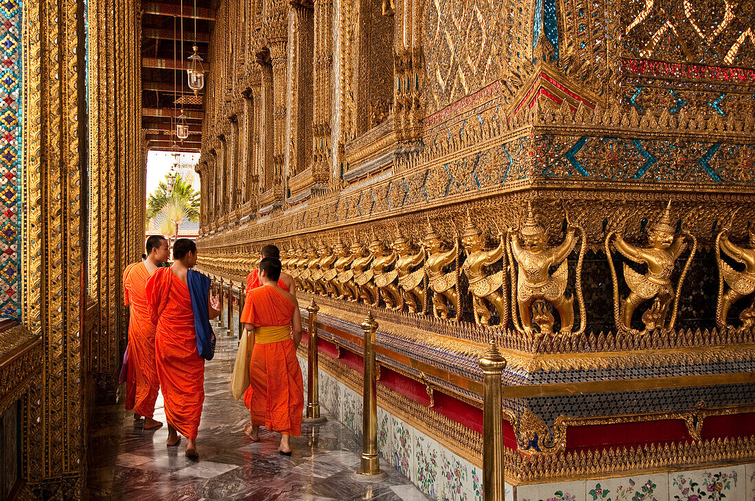 Buddhistische Mönche im Wat Phra Kaeo, dem Tempel des Smaragdbuddhas, auf dem Gelände des Grand Palace in Bangkok, Thailand.