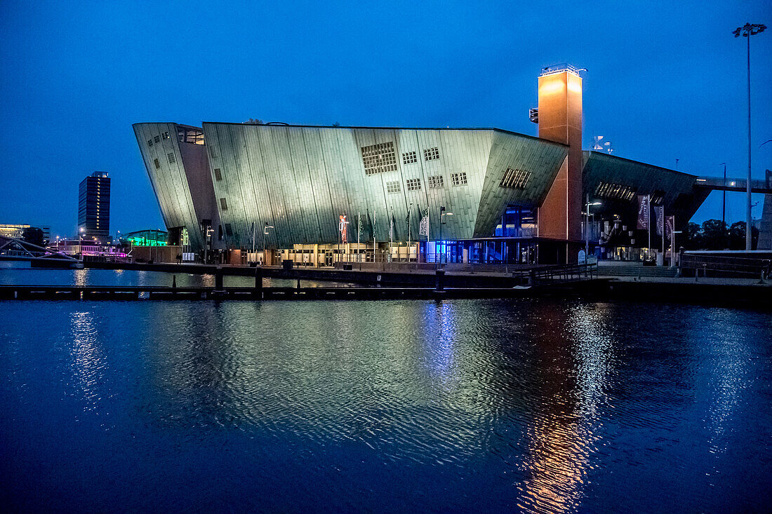 Amsterdam, Netherlands waterfront view of Nemo Science Museum shot at night.