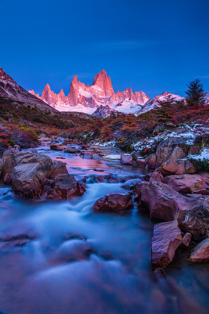 The Fitz Roy Massif in pastel pre-dawn morning twilight. Los Glaciares National Park near El Chalten, Argentina. A UNESCO World Heritage Site in the Patagonia region of South America. Mount Fitz Roy is in the tallest peak in the center. The creek in the foreground is the Arroyo del Salto.