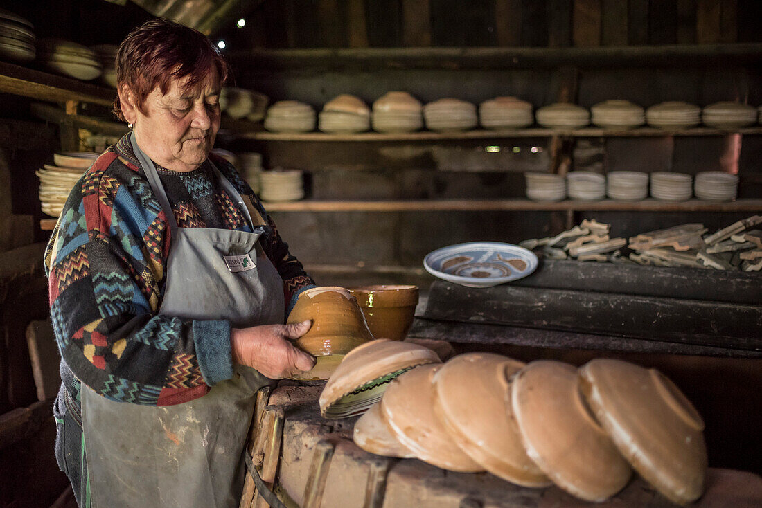 Frau bei der Arbeit an Horezu-Keramiken und Töpferwaren in ihrem Brennofen, UNESCO-Kulturerbe, Walachei, Rumänien