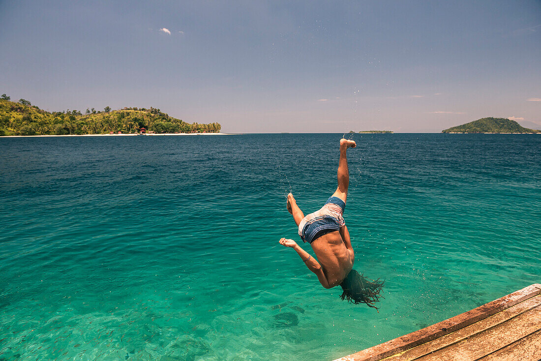 Back flip into the sea at Twin Beach, a tropical, white sandy beach near Padang in West Sumatra, Indonesia
