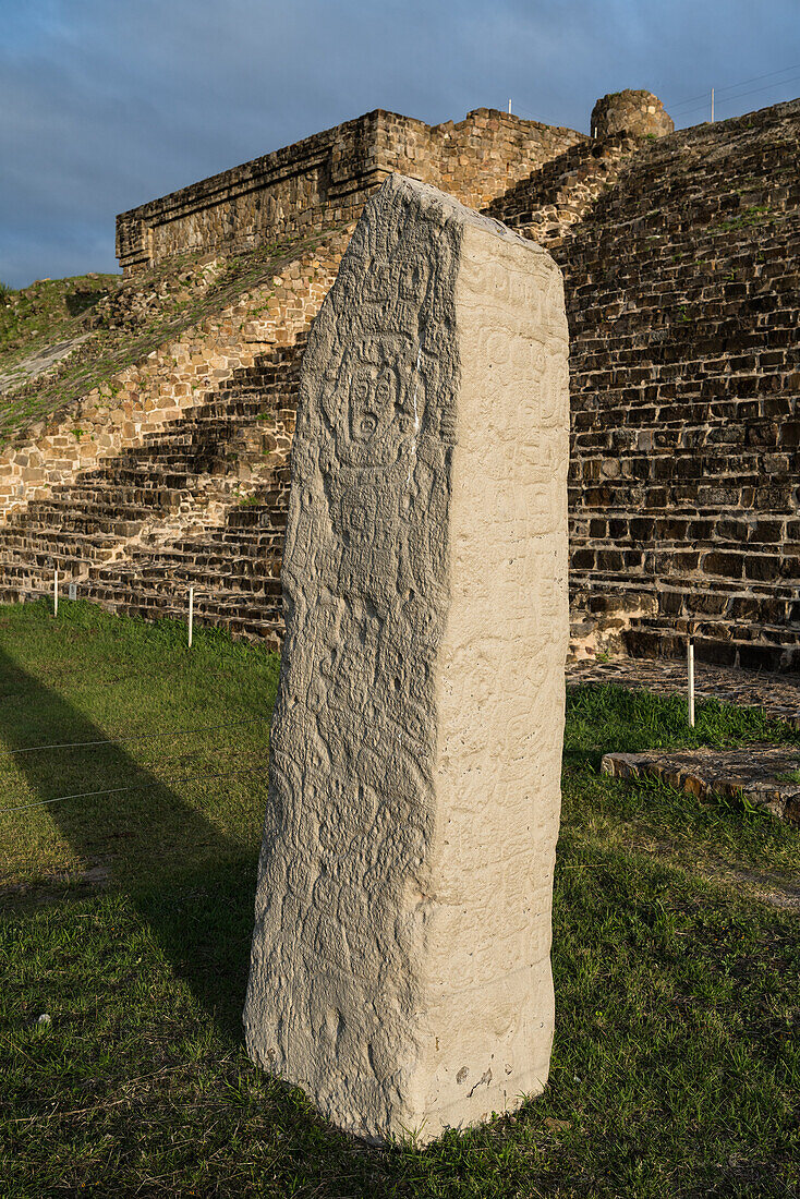 Stele 9 ist ein auf allen vier Seiten gemeißelter Steinobelisk vor der Nordplattform der präkolumbianischen zapotekischen Ruinen von Monte Alban in Oaxaca, Mexiko. Eine Stätte des UNESCO-Weltkulturerbes.