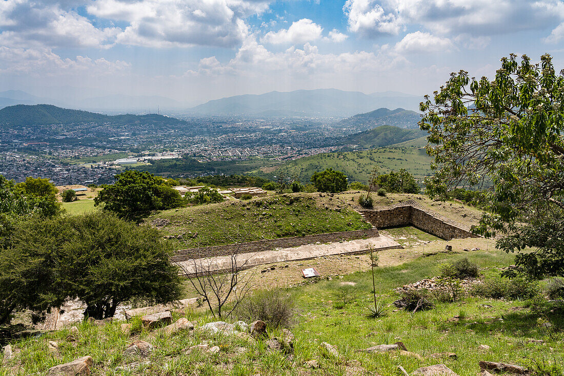Der große Ballspielplatz in den Ruinen der Zapotekenstadt Atzompa in der Nähe von Oaxaca, Mexiko. Im Hintergrund sind das Zentraltal und die Stadt Oaxaca zu sehen.